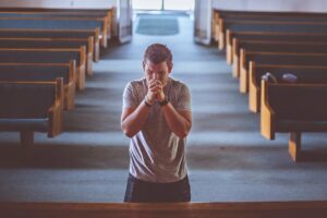 Młody człowiek modlący się w kościele