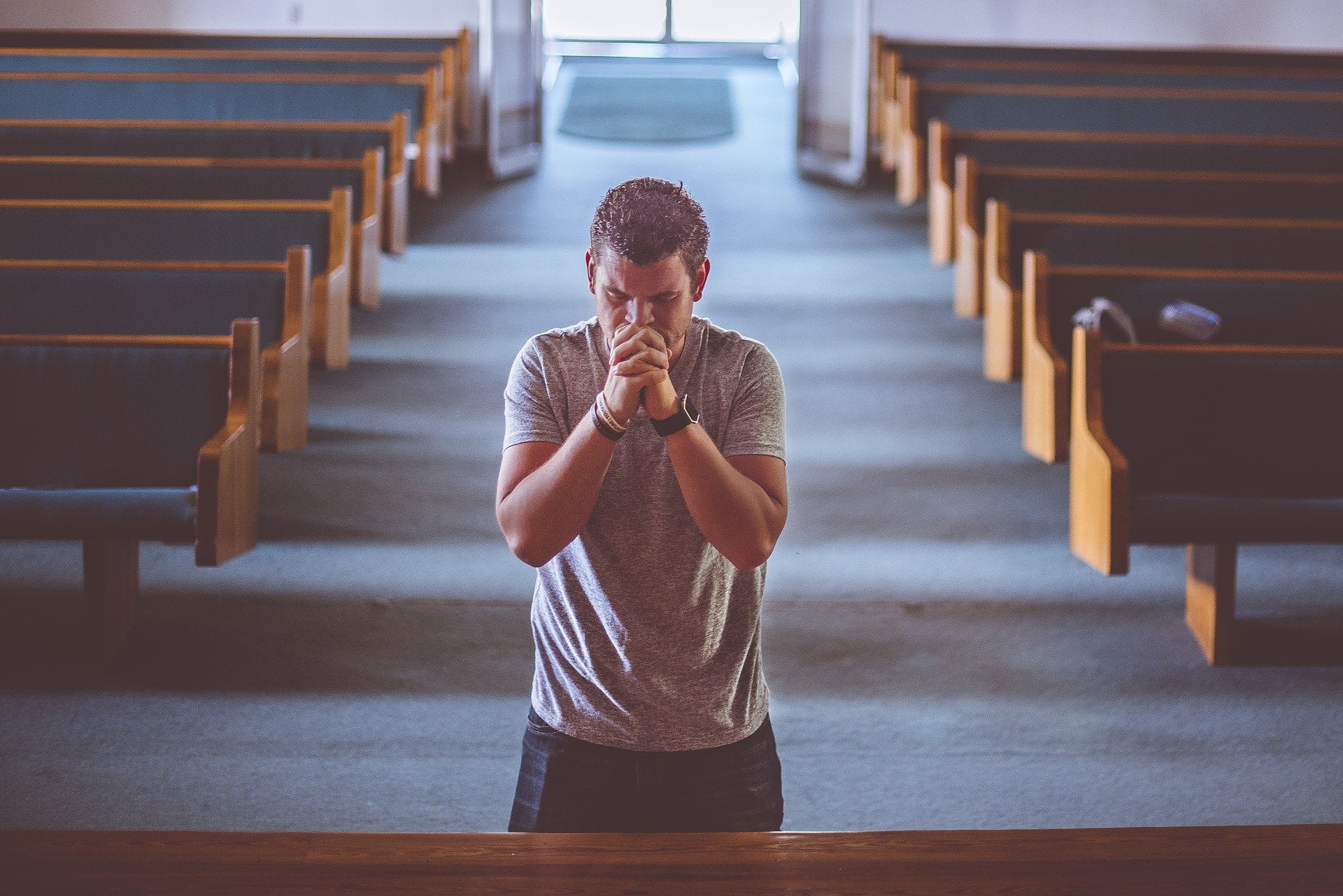 Młody człowiek modlący się w kościele