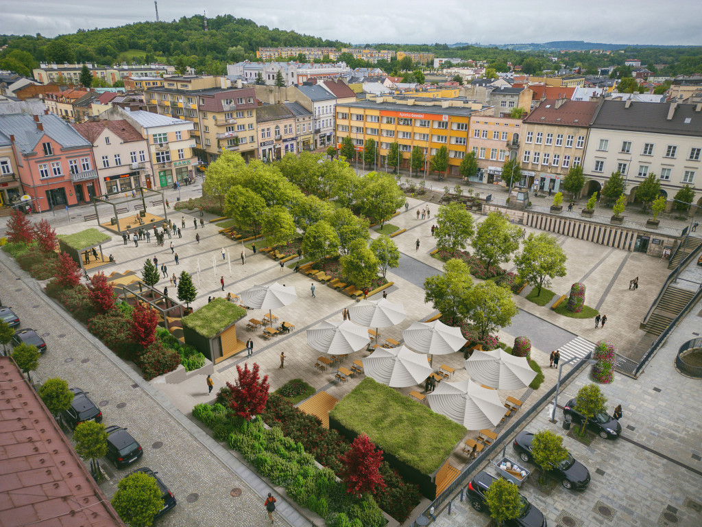 A bustling town square with green trees, benches, and white umbrella-covered seating areas surrounded by colorful buildings.
