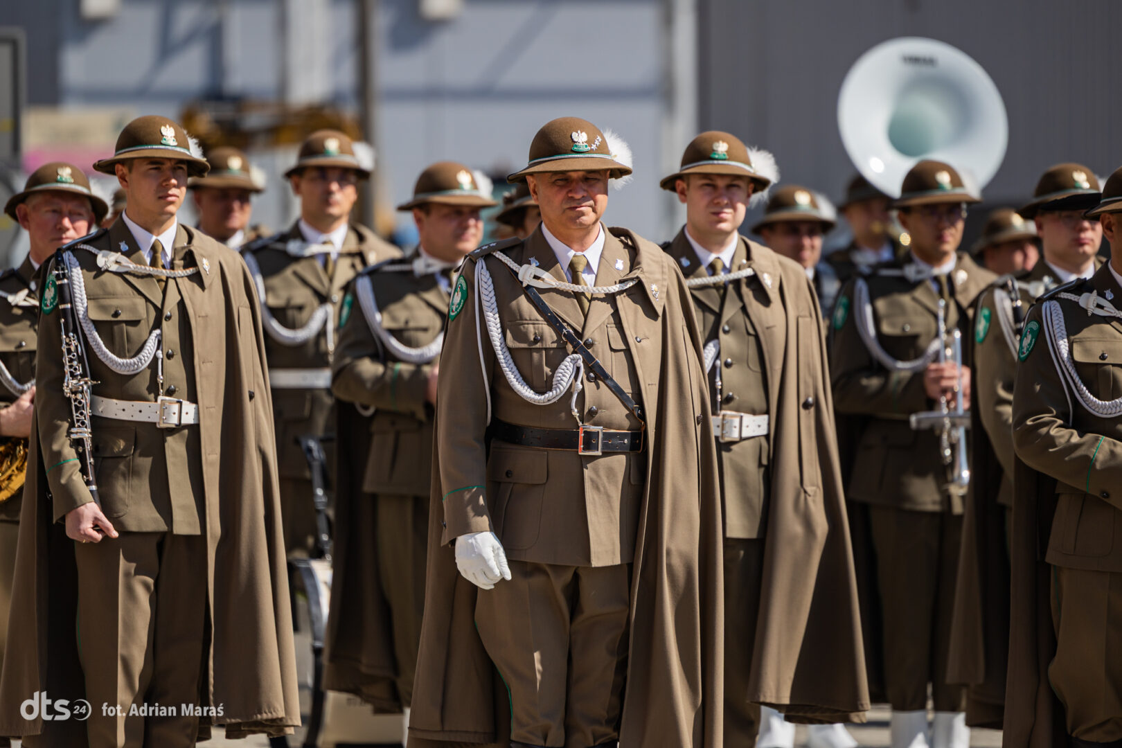 Group of soldiers in brown ceremonial uniforms standing in formation during a parade.