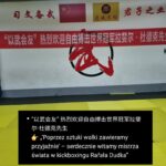 Dojo wall with a red Chinese banner welcoming world kickboxing champion Rafał Dudka; yellow mat in foreground.