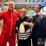 Three people posing with fists up in a store, smiling at the camera.