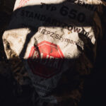 Crumpled white bag labeled 'MĄKA PSZENNA' (wheat flour) with red octagonal 'STOP' sign on a dusty ground surface.