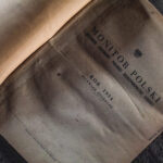 Old Polish government gazette titled 'Monitor Polski' from 1954, dusty and worn on a dark surface.