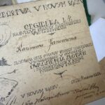 Antique parchment page with ornate handwritten Polish script and decorative flourishes, rotated in the image.