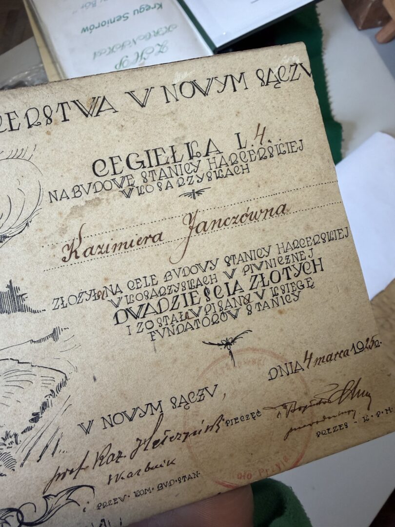 Antique parchment page with ornate handwritten Polish script and decorative flourishes, rotated in the image.