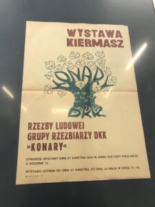 Poster in Polish advertising an exhibition, showing a stylized tree and leaves with the heading 'WYSTAWA KIERMASZ' and event details in smaller text below.