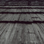 Close-up of weathered wooden planks with visible grain and nails, seen from a low angle.