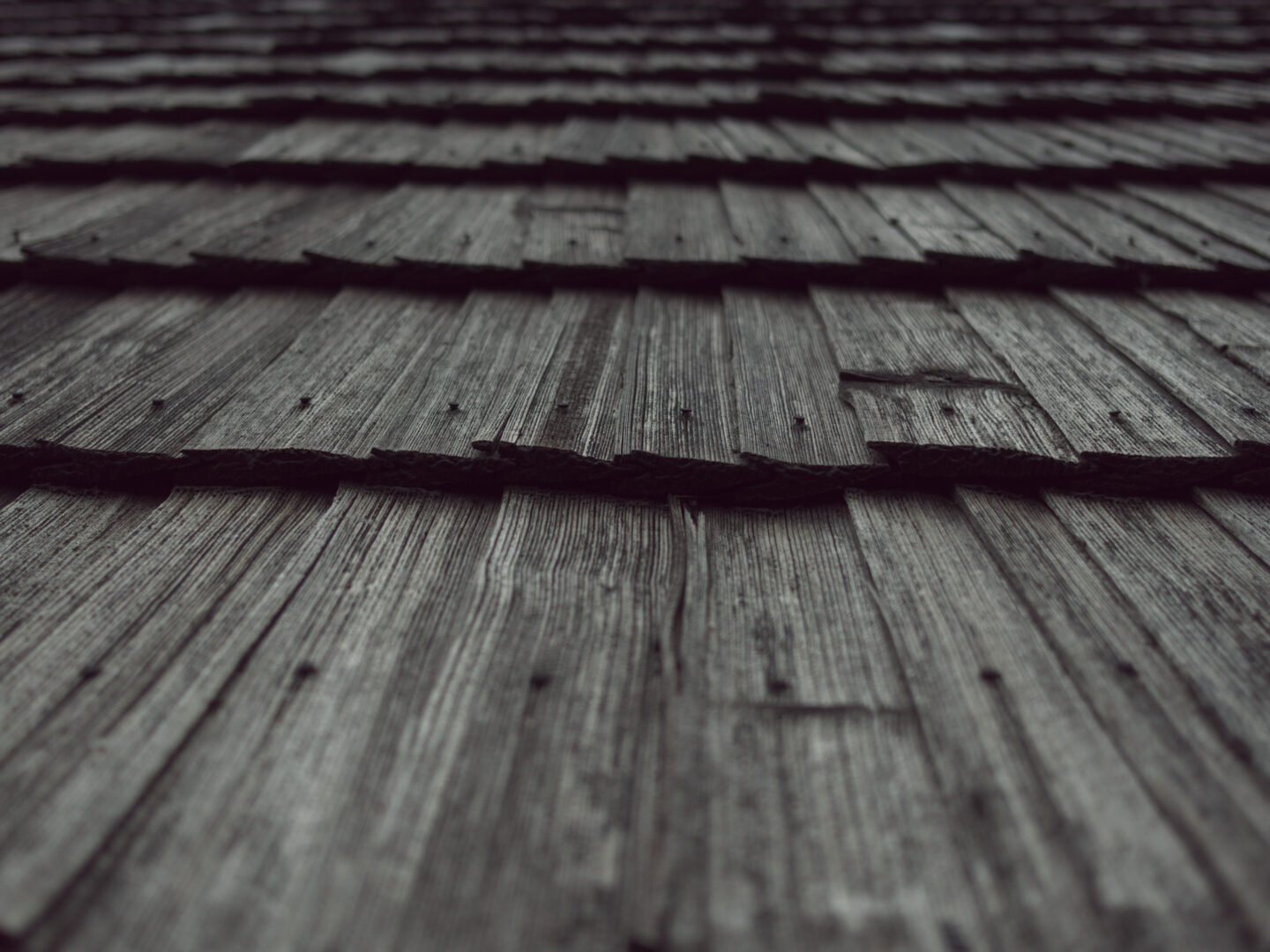 Close-up of weathered wooden planks with visible grain and nails, seen from a low angle.