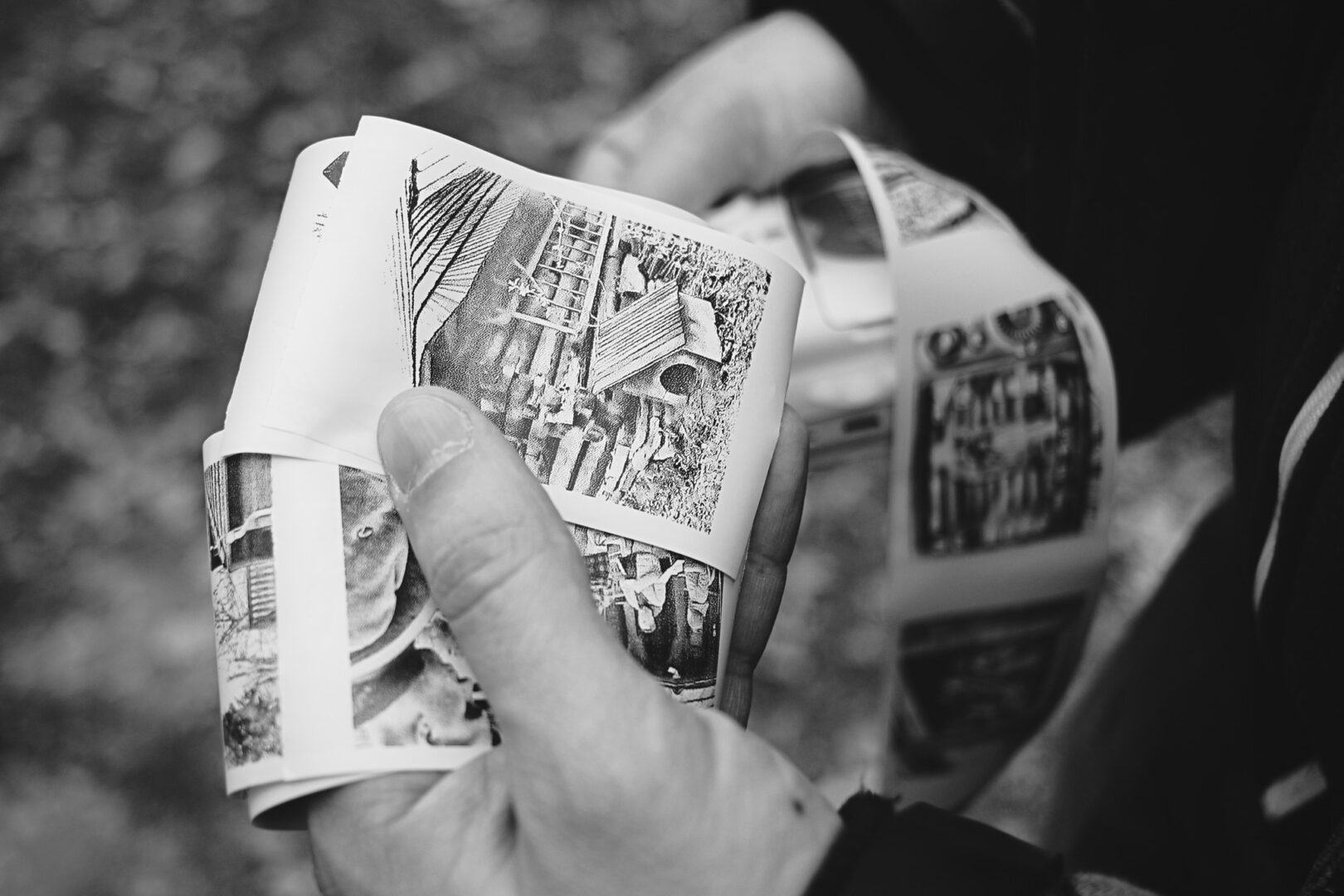 Close-up of hands flipping through a black-and-white photo album.
